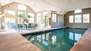 An indoor swimming pool with clear water, surrounded by lounge chairs and a sunbed. - Spacious Dog Friendly Retreat w/ Indoor Pool (Swanton)