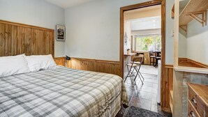 A bedroom with a bed, wooden paneling, a desk, and a chair. - A Cozy Mtn Abode in the Heart of Breck - Stylish Updates Throughout! | PM3C (Breckenridge)