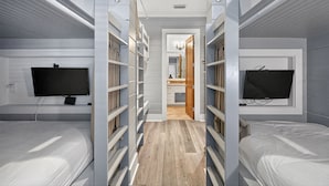 Een moderne slaapkamer met inbouwplanken, een televisie en een inloopkast.
