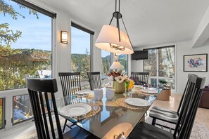 Enjoy meals with expansive mountain views from this dining area featuring a large table and comfortable seating for six.