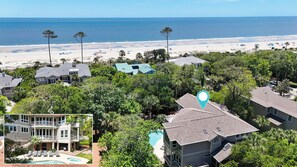 A coastal residential area with houses, a beach, and a pool.