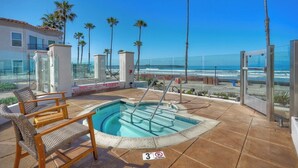 A rooftop pool with a view of the ocean, palm trees, and a glass-enclosed area with a chair and table. - Premium Beachfront Stay Ground Floor, 2 Parking Spots,  Community Jacuzzi EV Charging (Oceanside)