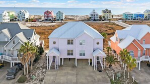 A beachfront residential area with colorful houses, a sandy beach, and a clear view of the ocean.