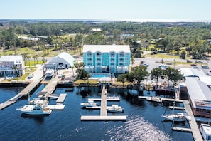 A marina with boats docked, a large blue building, and a waterfront view. - Waterfront, RIVERS EDGE CONDO 2A-BLDG 1 *PRIVATE DOCK and ASSIGNED BOAT SLIP (Steinhatchee)