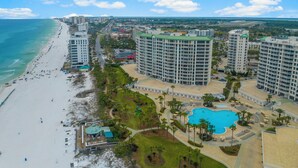 A coastal hotel with a beach view, multiple high-rise buildings, and a central swimming pool. - WELL APPOINTED & ELEGANT CONDO! GULF FRONT WITH SWEEPING VIEW (Destin)