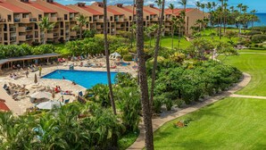 Un resort con piscina, sillas de descanso y palmeras.