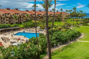 Un resort con piscina, lettini e palme.