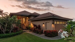 A two-story house with a well-maintained lawn, a front porch, and a garage. - Two-Story Private Home at Kamilo - Grill Deck, Pool & Sunset Views! (Kamuela)
