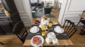 Ein Essbereich mit Frühstücksaufstellung, darunter Teller mit Speisen, Gläser Orangensaft und eine Kaffeekanne.