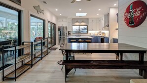 Une cuisine moderne avec un îlot central, des meubles blancs et une grande fenêtre.