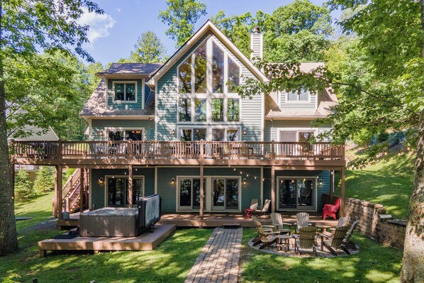 A two-story house with a balcony, outdoor seating area, and a fire pit.
