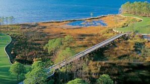 A golf course with a bridge and water bodies.