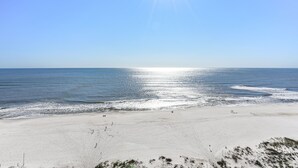 A beach with a clear sky and the sun shining. - Lighthouse 1112 by Liquid Life (Gulf Shores)