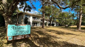 A two-story building with balconies, labeled "Atlantic Breezes," located at 2 Borden Lane, offering 8 two-bedroom vacation rental apartments managed by Jekyll Realty. - Atlantic Breeze #2 2 bedrooms, 1 bath (Jekyll Island)