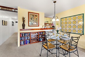 Charming dining space with fresh orchids, warm pendant lighting, and colorful tile artwork. Open layout perfect for relaxed meals and entertaining.