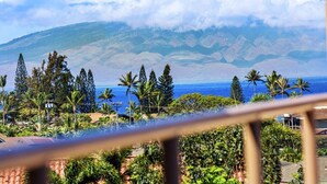 A view of a coastal landscape with mountains in the background, palm trees, and a clear sky. - Kahana Villas E308  Charming Condo (Lahaina)