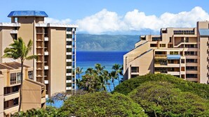 A hotel with multiple floors, balconies, and a view of the ocean. - Kahana Villas E308  Charming Condo (Lahaina)