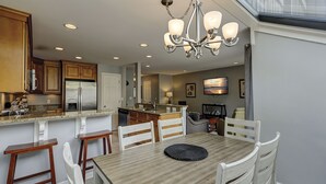 A modern kitchen with a central island, stainless steel appliances, and a chandelier. - 119 Beachwalk - 5 Minute Walk to the Beach - Enjoy a Pet Friendly getaway! (Hilton Head Island)