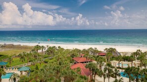 A beach resort with a pool area, palm trees, and a view of the ocean. - Beachfront ~ Gulf Views ~ Seasonally Heated Pool (Miramar Beach)
