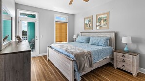 A bedroom with a wooden bed, a nightstand, a ceiling fan, and two framed pictures on the wall. - Waterfront, RIVERS EDGE CONDO #1B-BLDG 2 PRIVATE DOCK and ASSIGNED BOAT SLIP! (Steinhatchee)