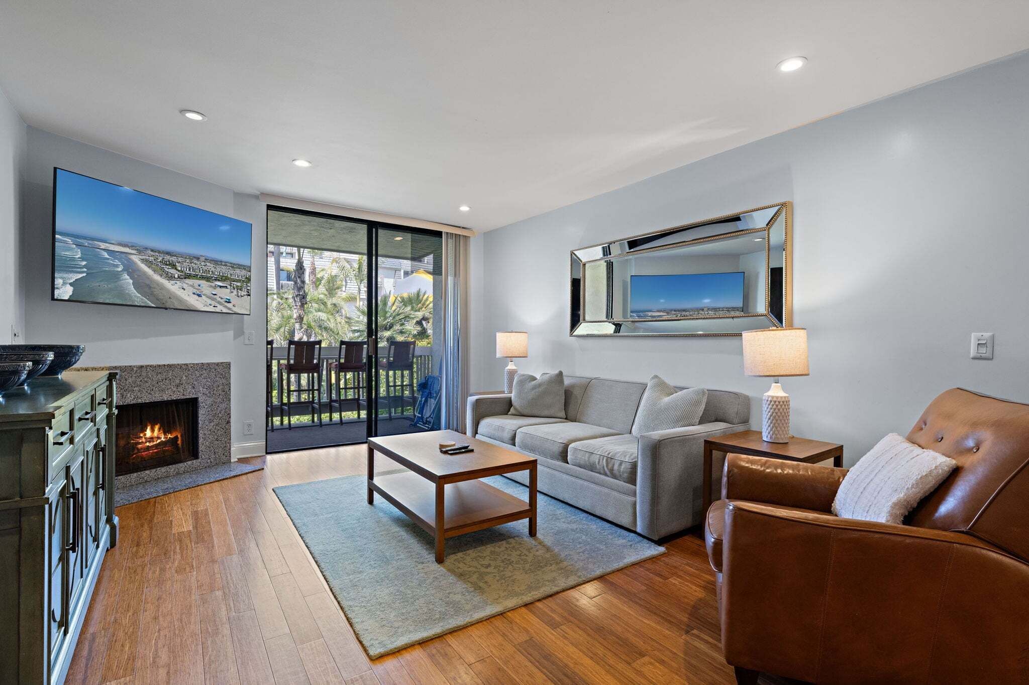 A modern living room with a fireplace, a sofa, a coffee table, and a TV.