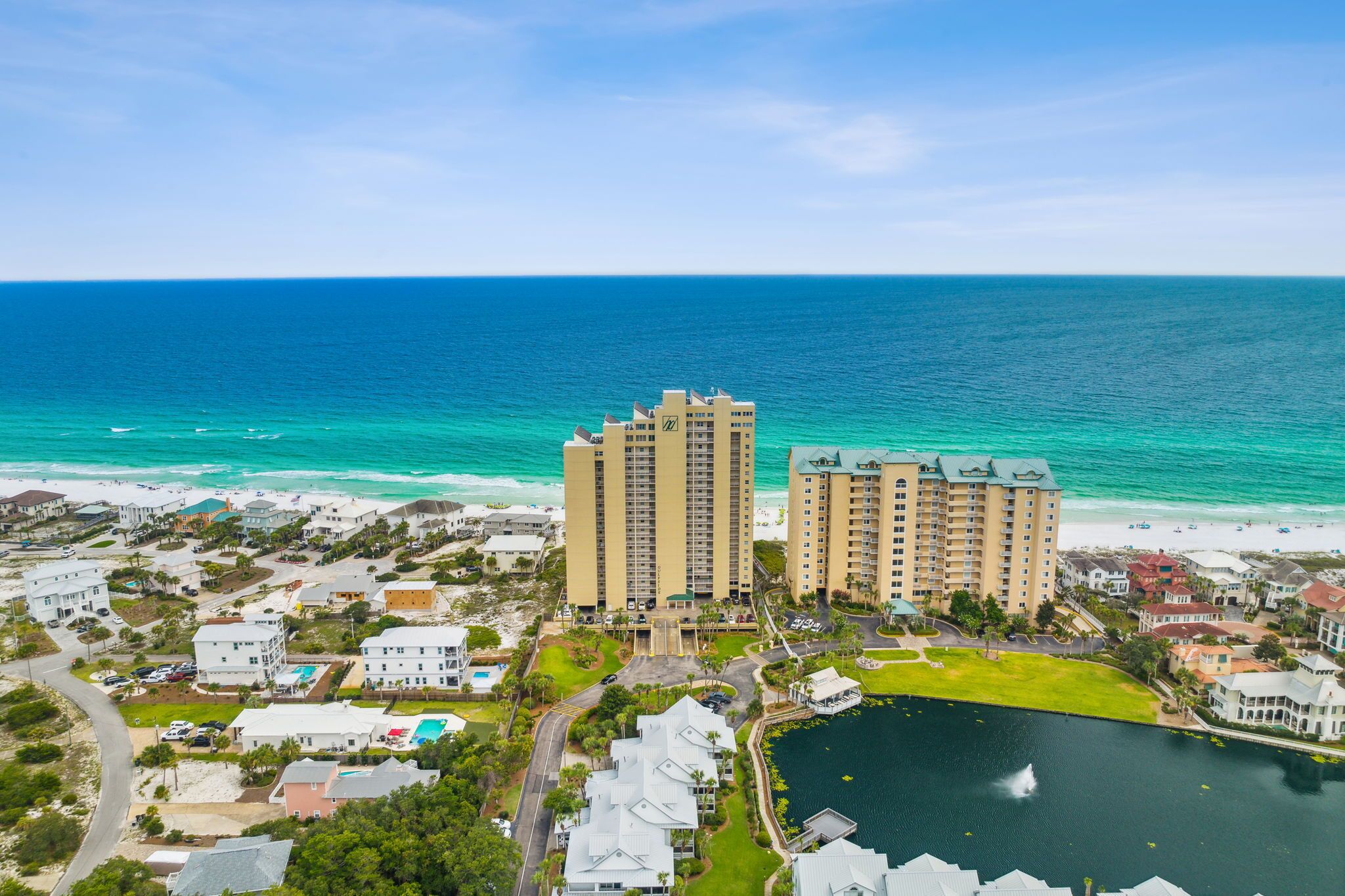 A coastal hotel with multiple high-rise buildings, a beach, and a marina.