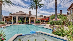 A pool area with a hot tub, palm trees, and a covered patio. - Best 2 Bedroom in Litchfield Park! Hot Community Pool, 1 car garage (Litchfield Park)