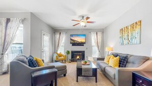 A living room with two sofas, a coffee table, a TV, and a fireplace. - Best 2 Bedroom in Litchfield Park! Hot Community Pool, 1 car garage (Litchfield Park)