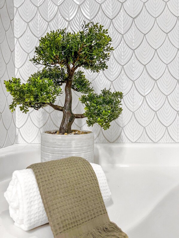 A small bonsai tree in a clear pot on a white surface with a textured wall in the background. - Best 2 Bedroom in Litchfield Park! Hot Community Pool, 1 car garage (Litchfield Park)