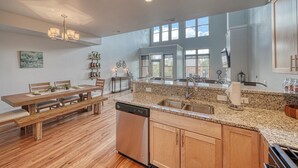 A spacious kitchen with a granite countertop, wooden cabinets, and a built-in dishwasher. - Highside Condo @ The River Lofts ~ New condo on the Arkansas River (Salida)