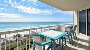 A balcony with a view of the ocean, a white railing, and a table with chairs. - 🌊Gulf Front🌊Onsite Bar and Grill🌊 Silver Beach Towers West 505 (Destin)