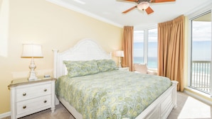 A bedroom with a bed, nightstands, lamps, a ceiling fan, and a view of the ocean. - 🌊Gulf Front🌊Onsite Bar and Grill🌊 Silver Beach Towers West 505 (Destin)