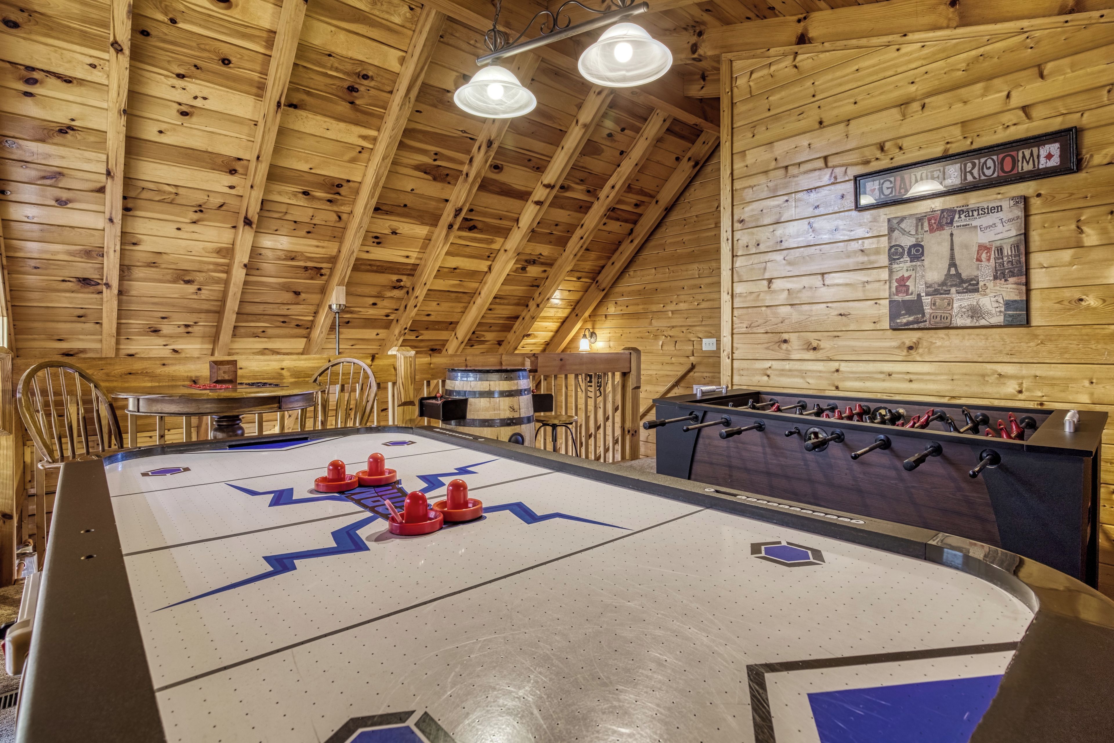 A wooden-floored room with a foosball table, a bar area, and a wall-mounted sign indicating a 'GIRL ROOM'.