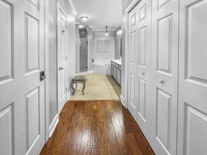 Stylish hallway leads to a bathroom area with a bathtub and sink.