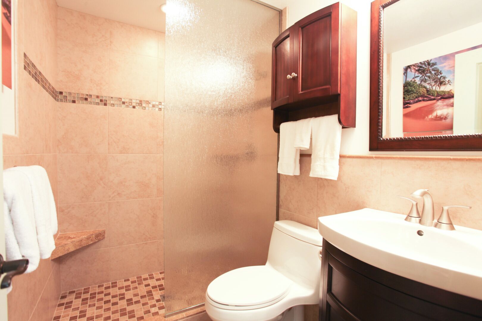 A bathroom with a shower, toilet, and sink.