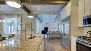 A spacious kitchen with granite countertops, stainless steel appliances, and a central island. - 52 N. Forest Beach-4th row (176 yard walk) to  ocean w/ elevator & much more! (Hilton Head Island)