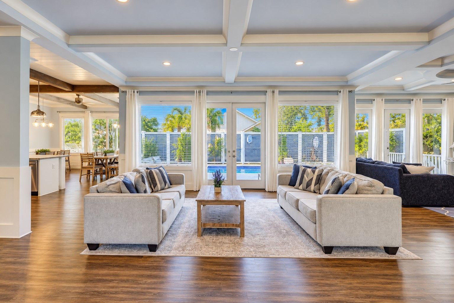 A spacious living room with a large window, a dining area, and a kitchen.