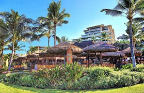 Relax in a tropical setting surrounded by lush greenery and thatched-roof structures.