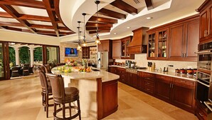 A spacious kitchen with a large island, wooden cabinets, and modern appliances. - Luxury Home, Casa Vista Paraíso, Pool, Rainforest View, Access to Amenities. (Puntarenas)