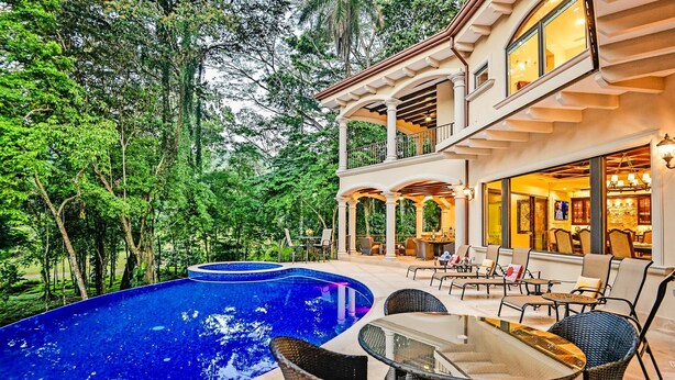 A luxurious outdoor pool area with a dining setup and a covered patio. - Luxury Home, Casa Vista Paraíso, Pool, Rainforest View, Access to Amenities. (Puntarenas)