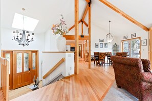 Relax in this inviting living area with a comfortable seating area, dining table, and staircase leading to an upper level.