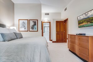 A bedroom with a bed, a dresser, and two framed pictures on the wall.
