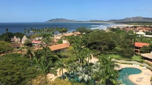 Un complexe hôtelier doté d’une piscine, d’une plage et offrant une vue sur l’océan.