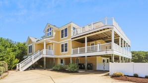 A two-story house with a balcony and a covered porch area.