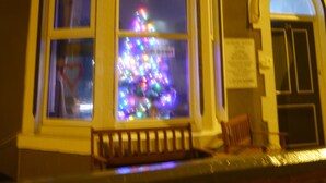 A building with a bay window displaying a Christmas tree. The building has a sign that reads "Hornby House." - Hornby House Hotel (Blackpool)