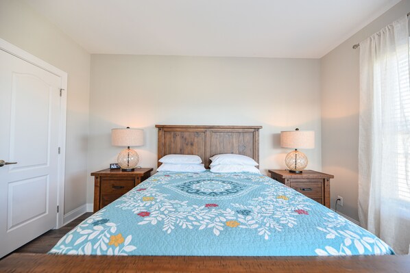 A bedroom with a bed, two bedside tables, and a nightstand.