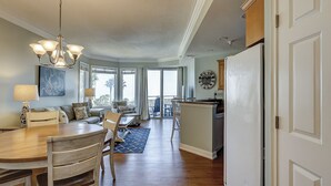 A spacious kitchen with a dining area, wooden cabinets, and a large window. - 1305 SeaCrest -3rd Floor OCEANVIEW (Hilton Head Island)