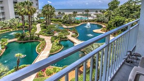A resort with multiple swimming pools surrounded by lush greenery, a beach in the background, and a view from a balcony. - 1305 SeaCrest -3rd Floor OCEANVIEW (Hilton Head Island)