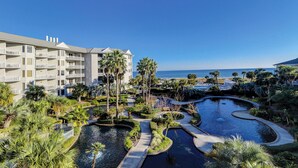 A resort with a pool area, palm trees, and a view of the ocean. - 1305 SeaCrest -3rd Floor OCEANVIEW (Hilton Head Island)