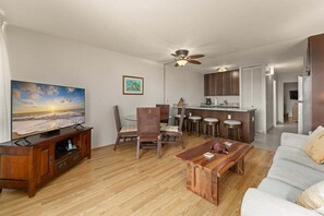 Un salon moderne avec un téléviseur à écran plat, une table basse en bois et un canapé.